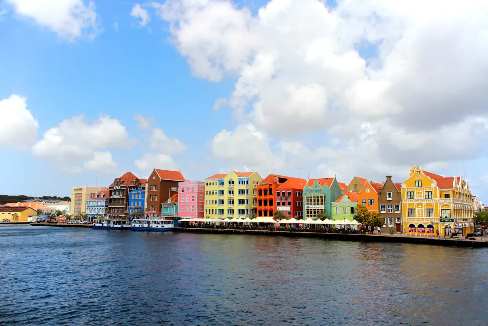 Wide view of the pastel waterfront houses along Curaçao's Handelskade